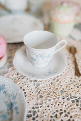 a teacup and saucer are on a table with a plate, tea time