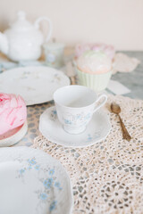a teacup and saucer are on a table with a plate, tea time