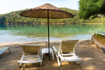 View of Blue Lagoon with Sun Loungers and Umbrellas at a Tropical Resort in Oludeniz, Turkey