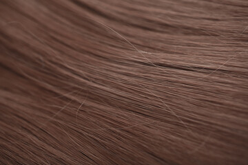Blond hair close-up as a background. Women's long light brown hair. Beautifully styled wavy shiny...