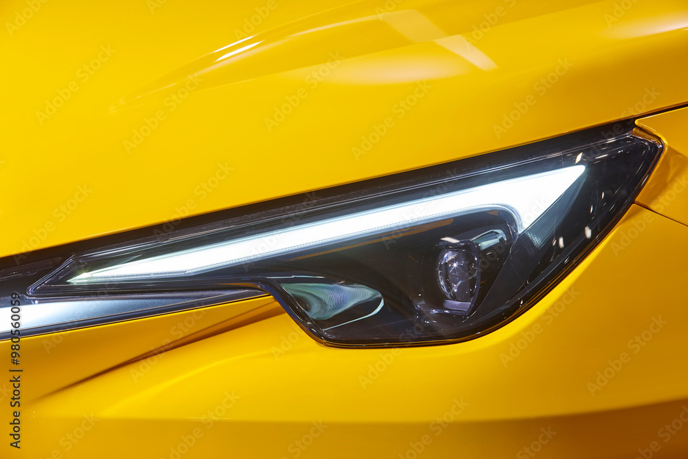 Wall mural yellow car headlight detail. elegant design car lights. motor industry