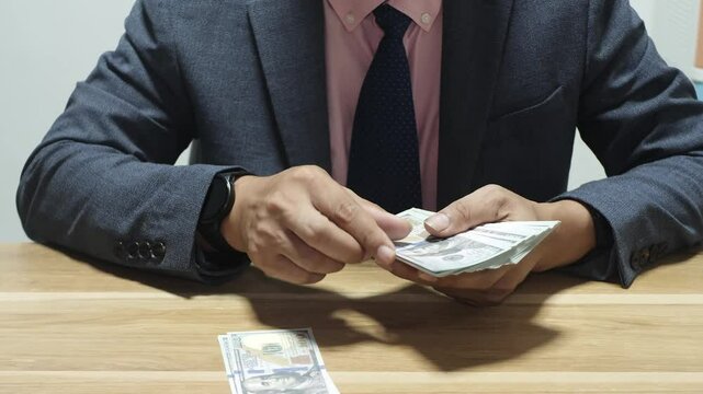 Bank teller working and counting 100 dollar bills