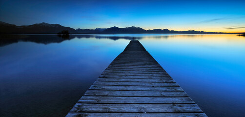 Fototapeta premium Panorama of Wooden Pier by Lake Chiemsee at Sunset against the Alps, Bavaria, Germany