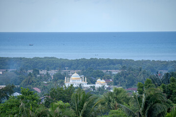Obraz premium The Dome of a Mosque Surrounded by Lush Greenery in Lhokseumawe, Indonesia
