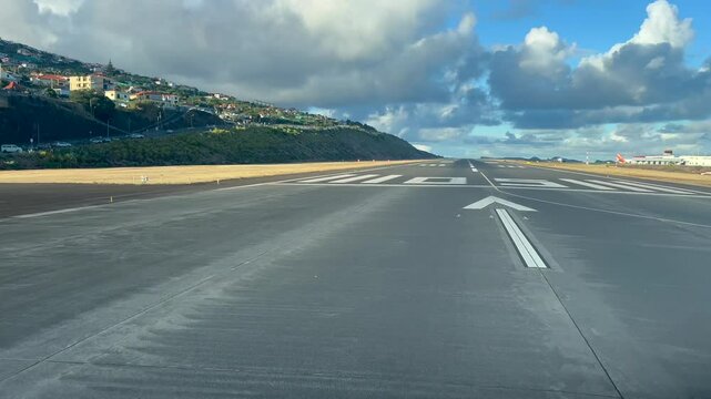 Real time initial take-off roll seen from the cockpit of a jet airplane departing from Funchal Madeira airport before sunset, with a blue sky and some fluffy clouds. Immersive pilot&rsquo;s perspective. 4K
