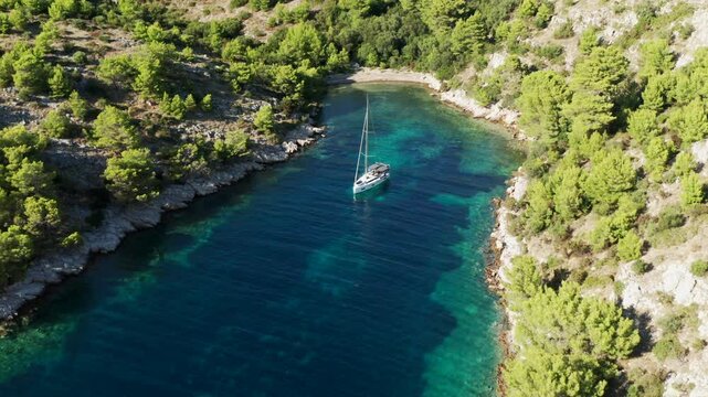 Yacht On Adriatic Coast With Vegetation On Uska Bay, Lastovo, Croatia. aerial pullback shot