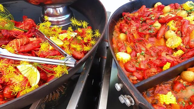 Plenty of seafood is served in the huge pans at the traditional Swedish crawfish party. The colorful seafood with pieces of lemons and corn mixed.