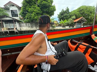 Hombre en barca tradicional tailandesa en los canales de Bangkok