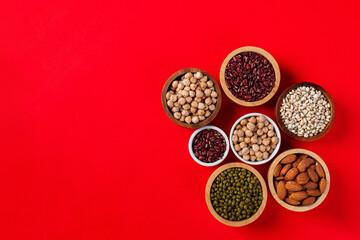 Mung beans, Red kidney beans, Chickpeas source and peeled barley in a basket wooden isolated on red background