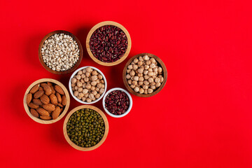 Mung beans, Red kidney beans, Chickpeas source and peeled barley in a basket wooden isolated on red background