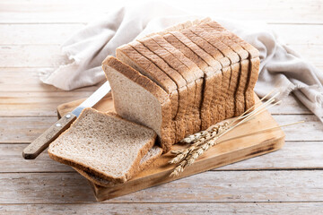 Healthy wholemeal bread slices isolated on wooden table