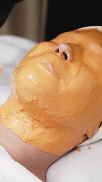 Close-up of a cosmetologist applying an alginate mask in a contemporary skincare center. This scene highlights the precision and expertise involved in advanced facial treatments.