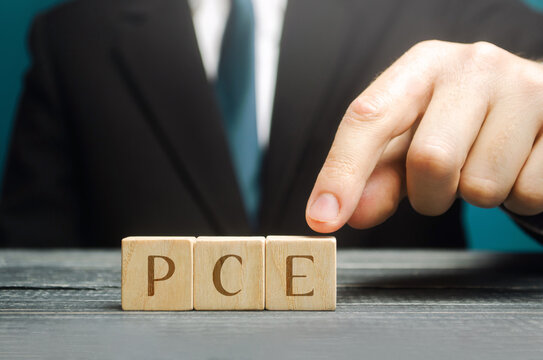 Inscription PCE - Personal Consumption Expenditures on a blocks in a hand businessman. Measure of consumer spending. Business and finance concept