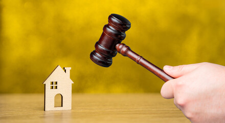 Judge's gavel near miniature wooden house. Real estate court decisions. Property inheritance...