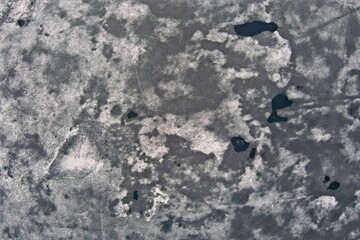 Abstract aerial view of frozen lake surface in spring when it has started to melt.