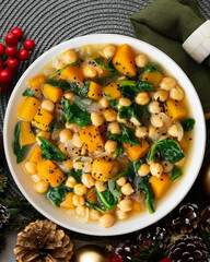 Chickpea stew with pumpkin and spinach. Top view table with Christmas decoration.