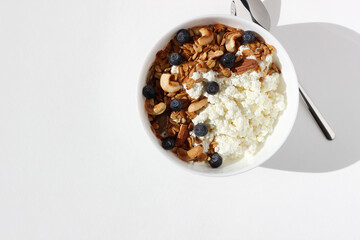 Eating Breakfast. Cottage Cheese with Homemade Granola, Cashew Nuts, Almonds, Seeds and Blueberries. Healthy Morning Nutrition.