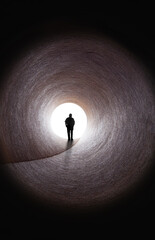Man walking out of tunnel to bright light