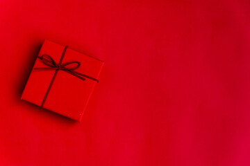 red gift box with ribbon on red space for text. chritsmas and new year celebration