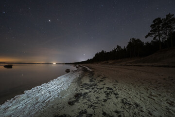 Kaberneeme beach early winter night with starry sky, landscape astrophotography in Estonia.