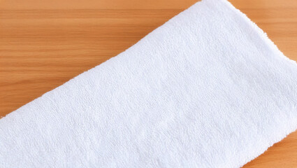 White towel neatly folded on wooden surface