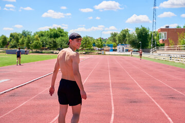 Fototapeta premium Smiling athlete walking on track during training