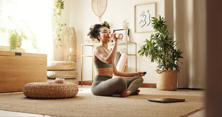 Woman, drinking water and yoga in home for fitness, peace or thirsty in session on floor. Girl,...