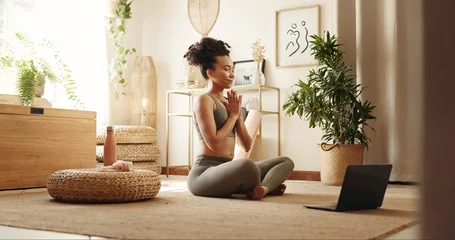  Home, yoga and woman with laptop, meditation and peace with chakra, spiritual routine and calm. Apartment, healthy person and girl with pc, lotus or posture with exercise and wellness in living room © PeakPoints/peopleimages.com