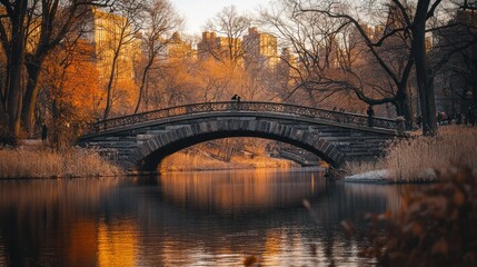 A tranquil bridge over a reflective waterway in a serene autumn landscape.