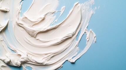 Creative art process with white paint smeared across a textured blue canvas on a bright, sunny day