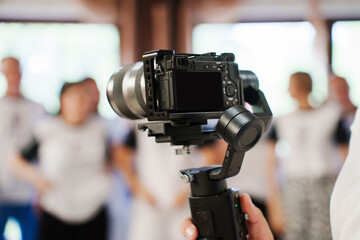 A professional camera against the background of people out of focus. Shooting of holidays and team...