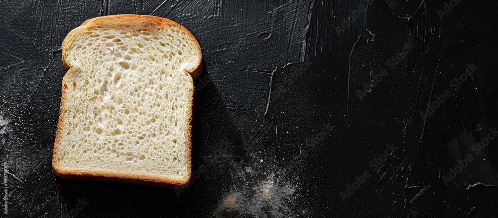 Poster close up of a slice of white bread on a black background with a textured surface and copy space imag