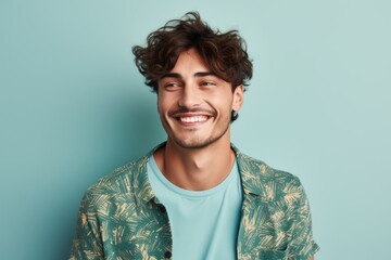 Fototapeta premium Portrait of a satisfied man in his 20s donning a trendy cropped top while standing against soft blue background