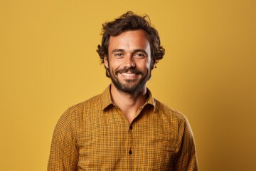 Fototapeta premium Portrait of a content man in his 30s wearing a comfy flannel shirt while standing against soft yellow background