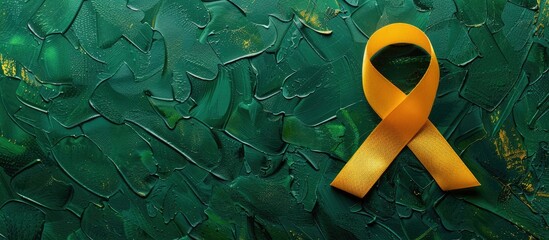 Top view of a yellow awareness ribbon on a green surface with copy space image for adding text