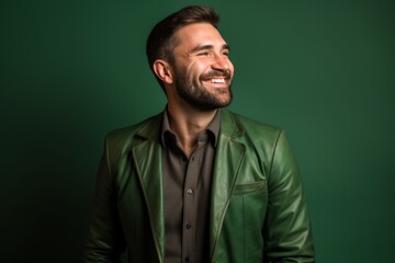 Fototapeta premium Portrait of a blissful man in his 30s sporting a stylish leather blazer in soft green background