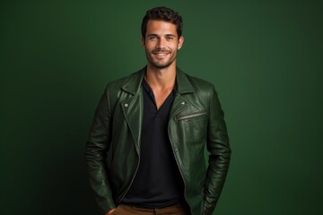 Fototapeta premium Portrait of a blissful man in his 30s sporting a stylish leather blazer in soft green background