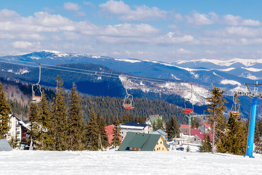 Aerial view ski slope,pine trees,village rural house,hotels in snow in winter forest mountains,nature. Alpine ski resort,Carpathians,Dragobrat
