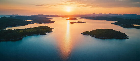 Fototapeta premium Aerial drone shot of a serene lake coast at sunset with islands and a clear view ahead ideal for use as a copy space image