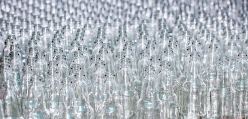 Glass factory, production of glass containers. Molten glass is blown into molds. Robotics in industry. Modern technologies, robotic machines produce products. Technological work at the plant.