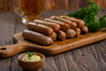 A close-up shot of perfectly grilled sausages stacked on a wooden board. The sausages are garnished with fresh parsley, highlighting their juicy texture and inviting appearance for a delicious meal