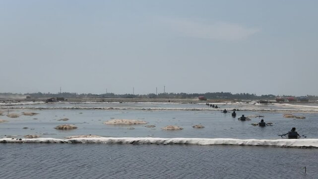 The reclamation project in the Pantai Indah Kapuk 2 - PIK 2 area, North Jakarta. A pump is used to drain seawater and trucks are transporting filling materials.