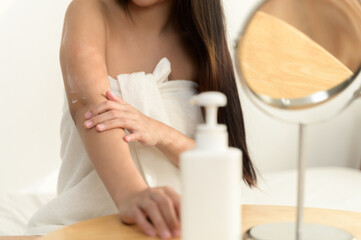 Close up hand of young Asian woman applying skin care cream lotion on her arm. Woman beauty selfcare cosmetic caring routine concept.