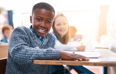 Desk, portrait and kids in classroom for lesson in growth, happy child development and notebook for education. Smile, learning and students with exam notes, knowledge and study at elementary school