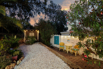 Garden with wooden gazebo in the evening. The sky at sunset, a place of privacy and relaxation.