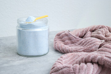 Close up of washing powder and a dirty towel on grey table. Cloth stain remover concept