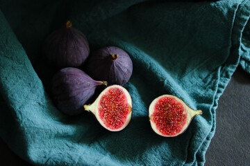 Close up of fresh ripe fig fruits in green fabric with dark shadows