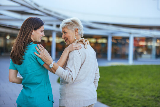 Nurse Caring for Elderly Woman Outdoors in Hospital Setting