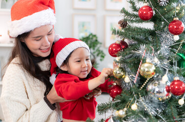 Little child with mother joyful moment celebrating together at home during the Christmas season