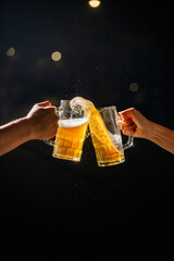 Two hands raise beer mugs overflowing with foam in a lively toast to celebrate Oktoberfest. The...